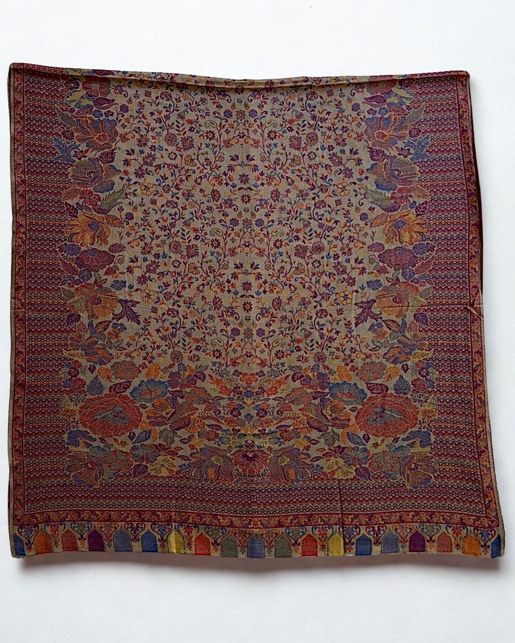 Antique rose Kani pashmina shawl folded back to show the reverse of the woven floral pattern and the arcaded border