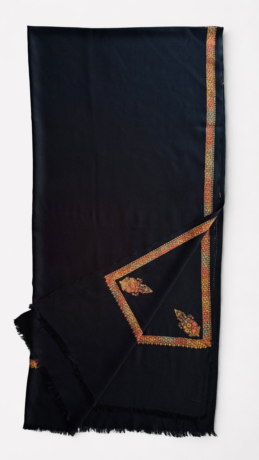 Close view of the embroidered border in saffron, coral, gold and pale blue on black