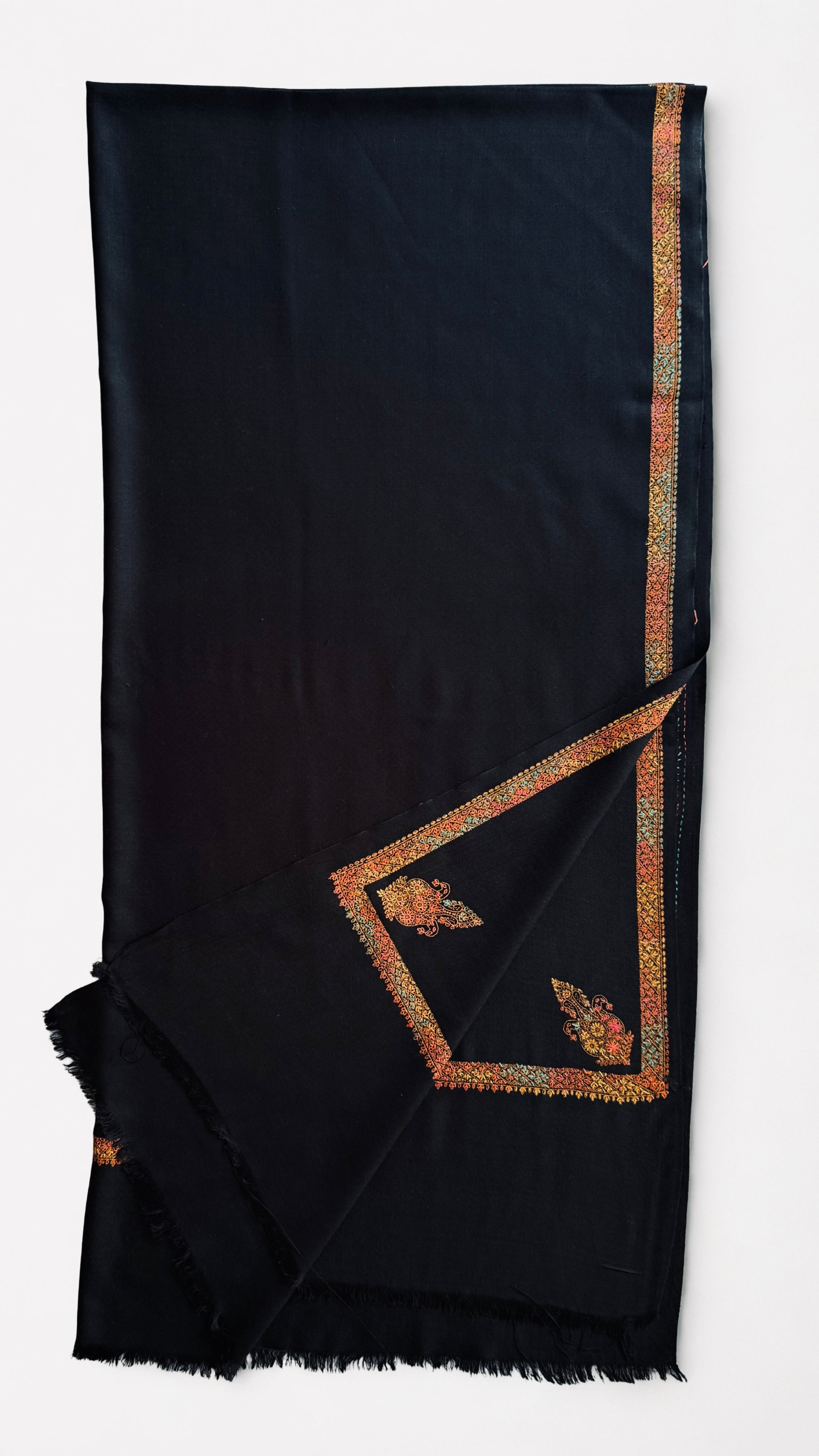 Close view of the embroidered border in saffron, coral, gold and pale blue on black