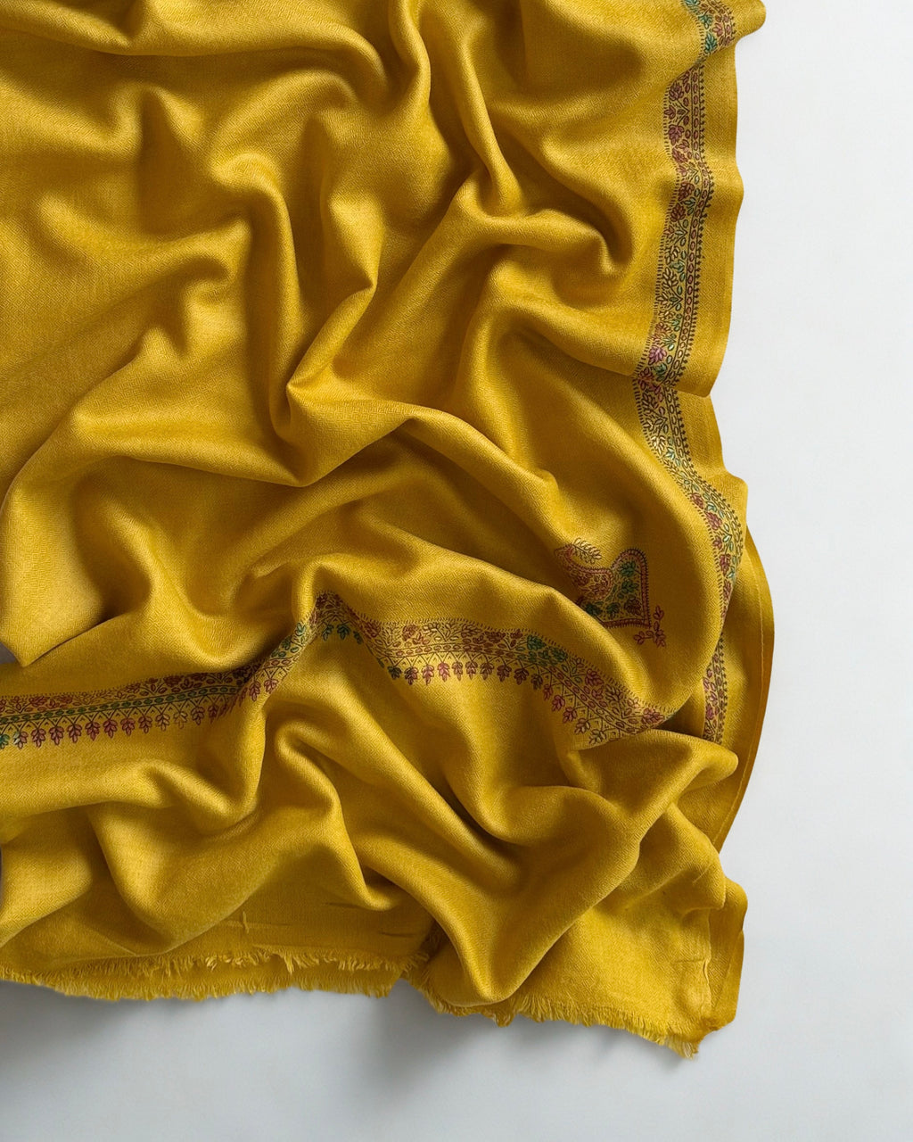 Mustard gold Swati Shahtoosh shawl folded back to show both corner buta and the fine sozni border