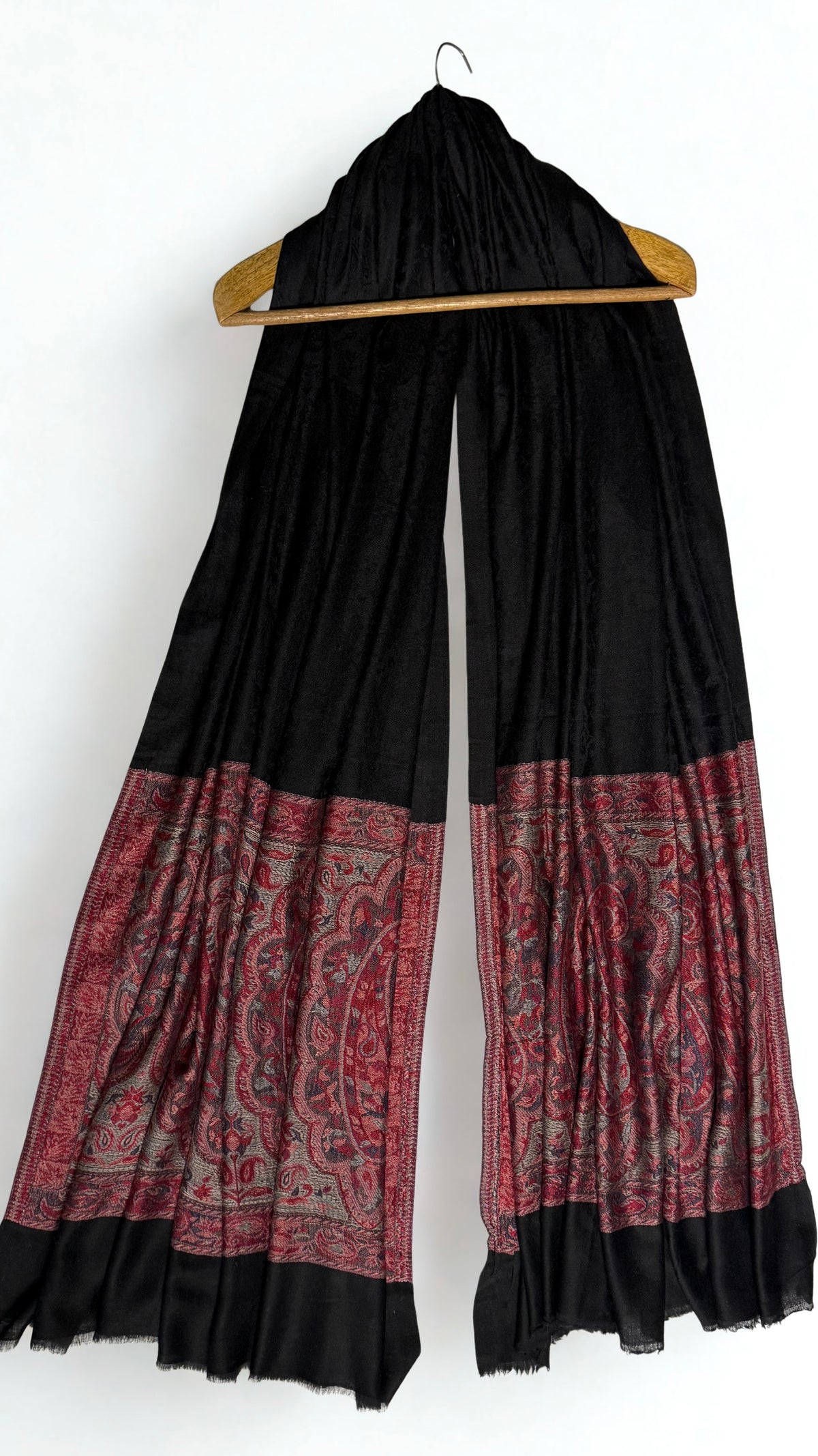 Black Palladar ring shawl on a hanger, showing the drape and the self-coloured paisley catching the light