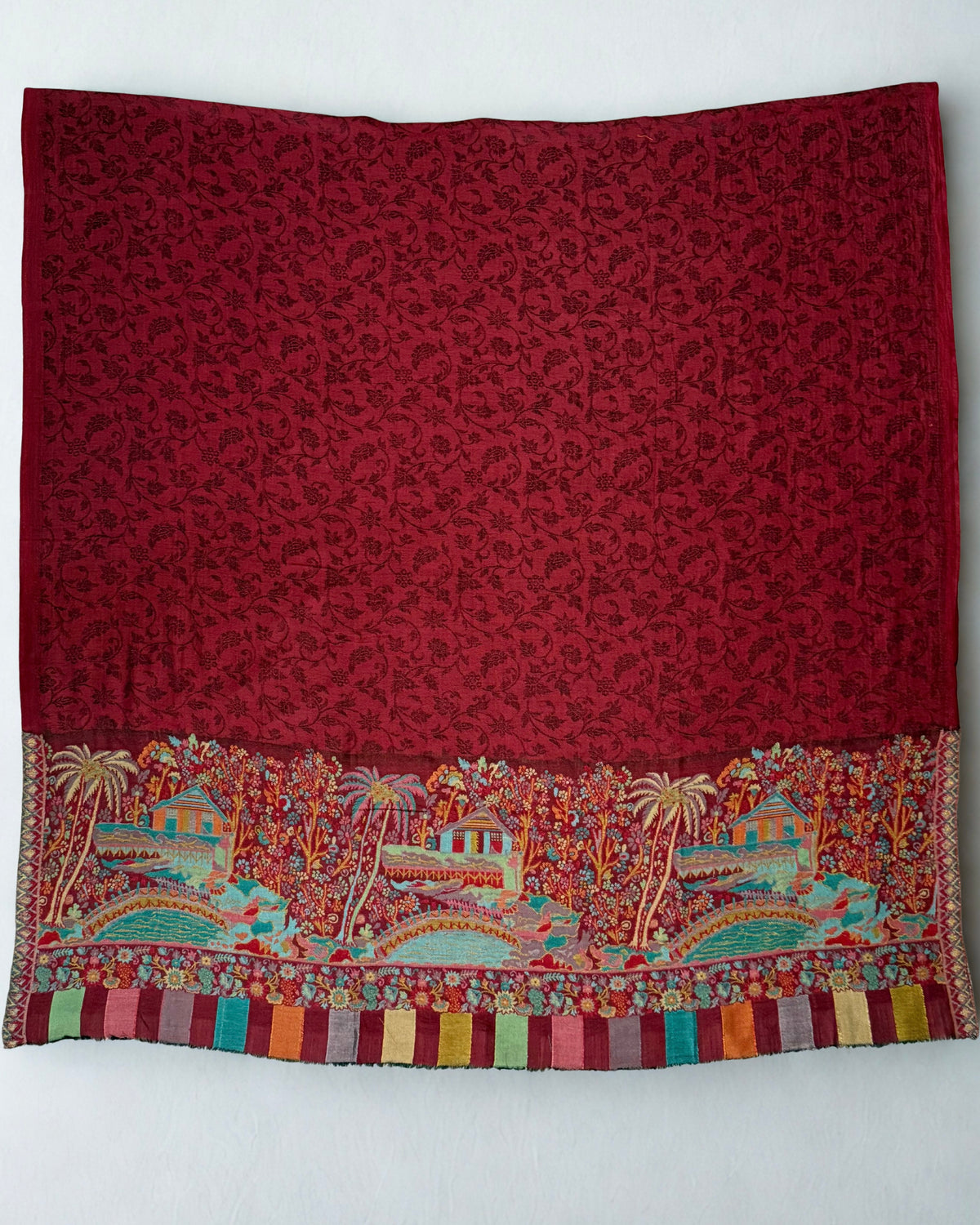 Maroon pashmina shawl on a wooden hanger, both landscape end panels visible