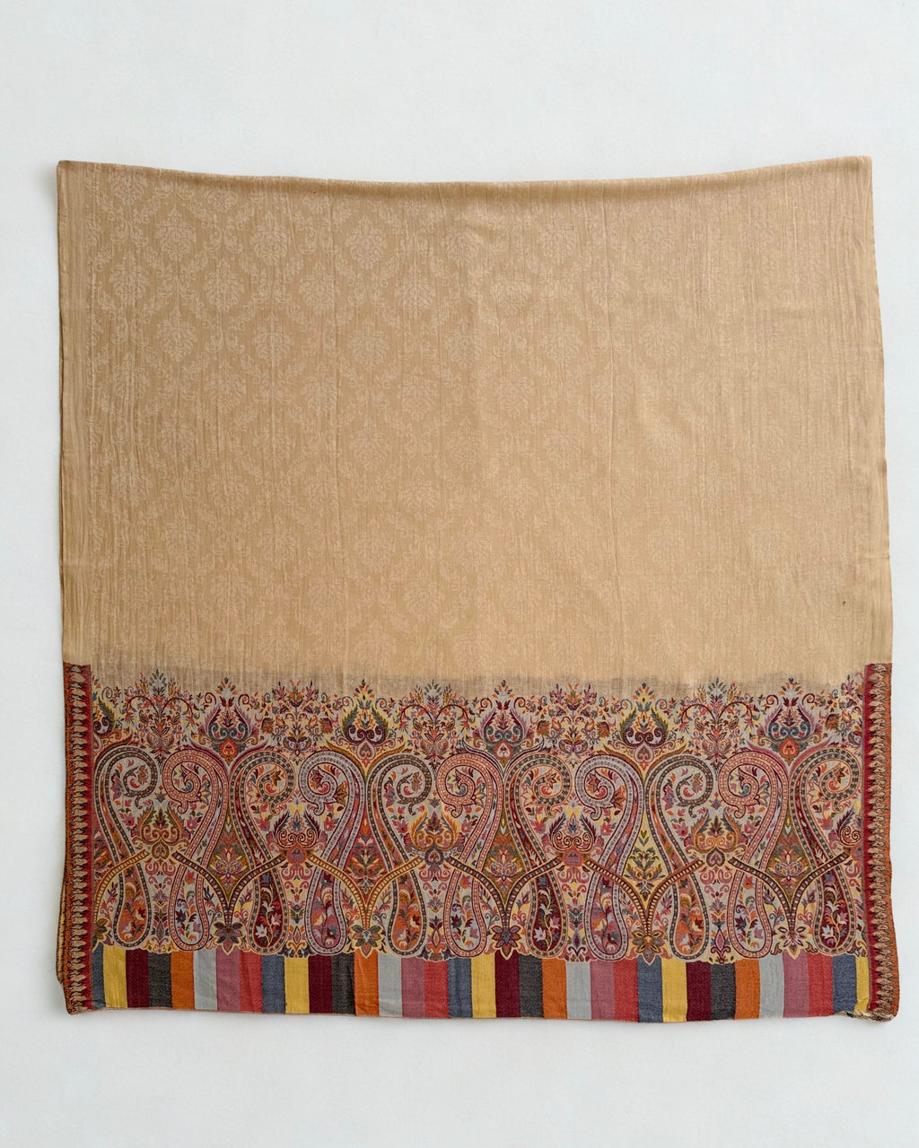 Close view of the paisley border in rose, saffron, slate blue and coral on a pale ground