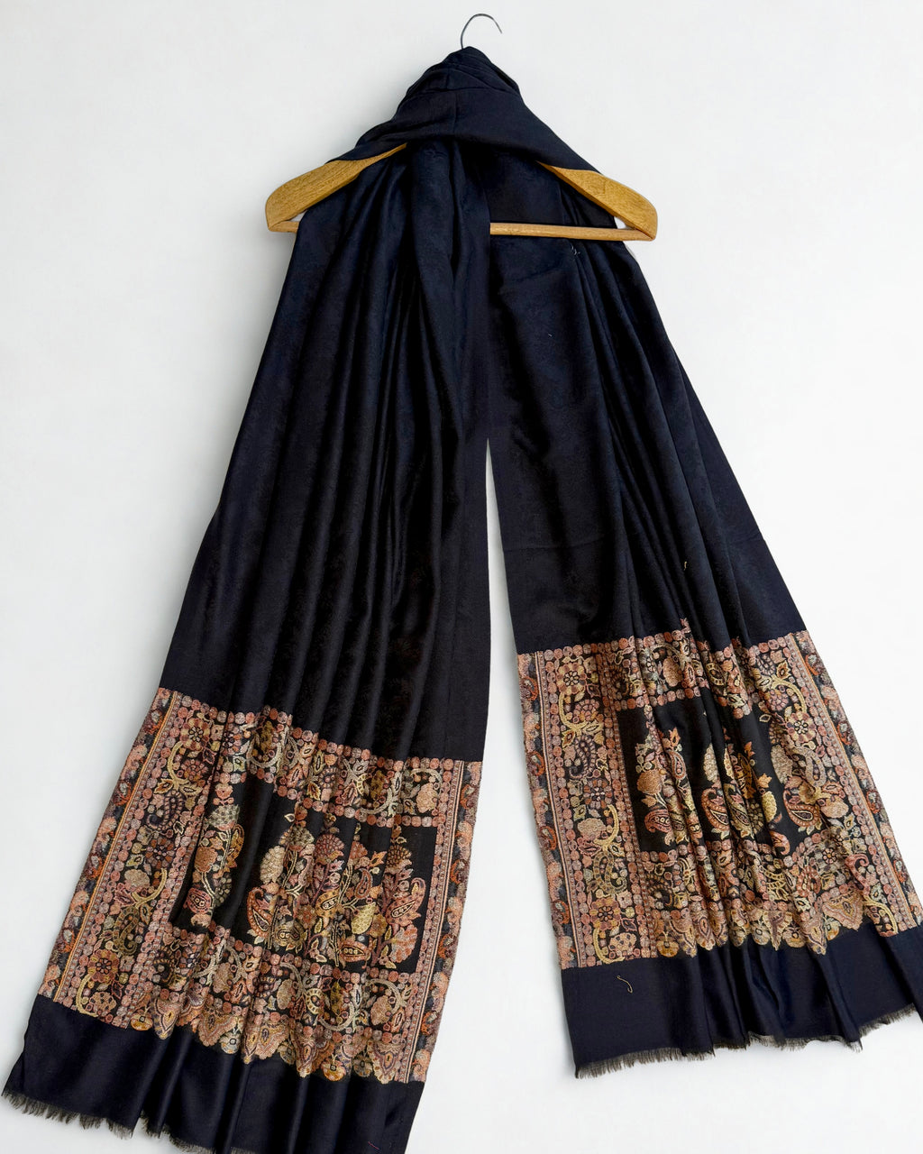 Navy Palladar shawl on a wooden hanger showing both end panels and the fringed edge