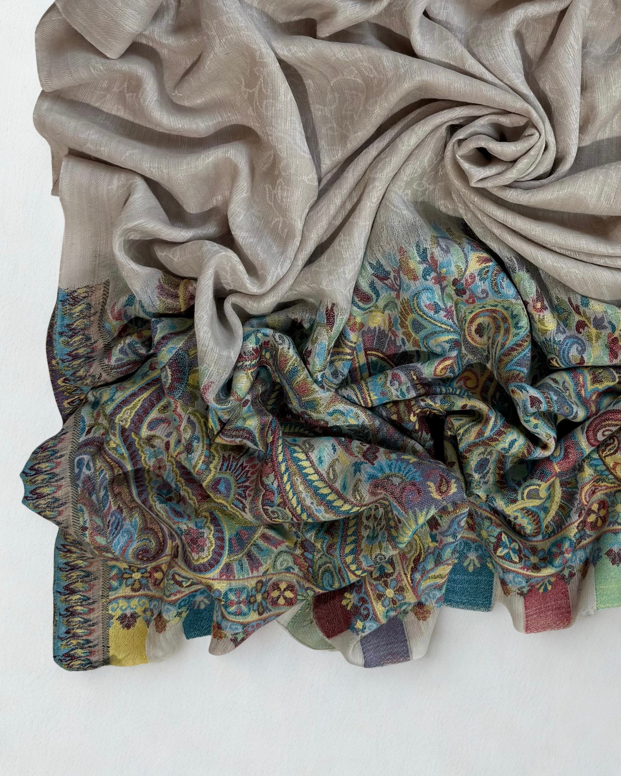 Full view of the stone grey pashmina shawl with its turquoise paisley end panel