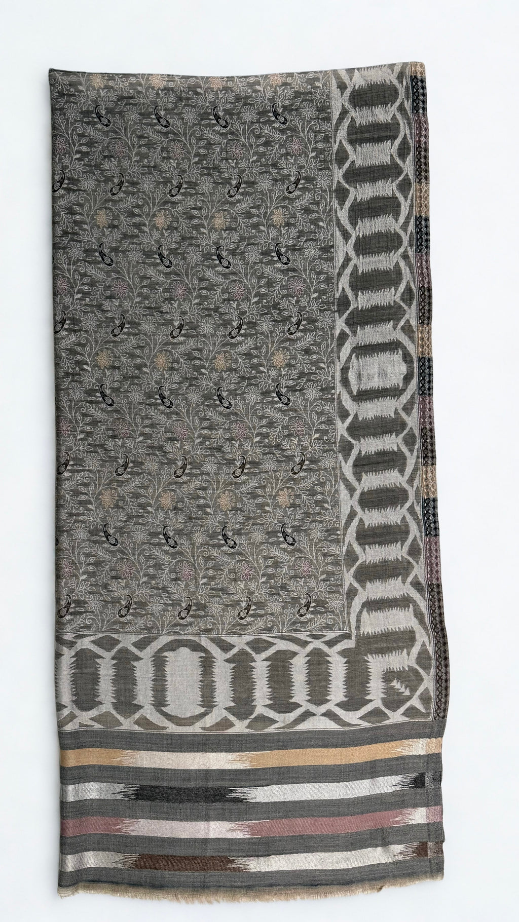 Full shawl laid flat, patterned edge to edge with flowering vine and framed by woven borders on all four sides
