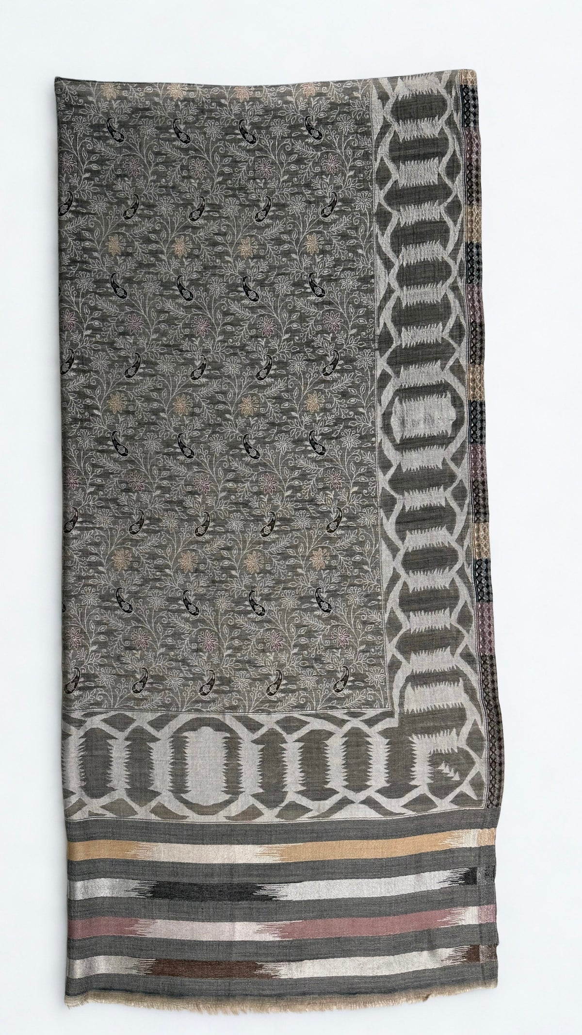 Full shawl laid flat, patterned edge to edge with flowering vine and framed by woven borders on all four sides