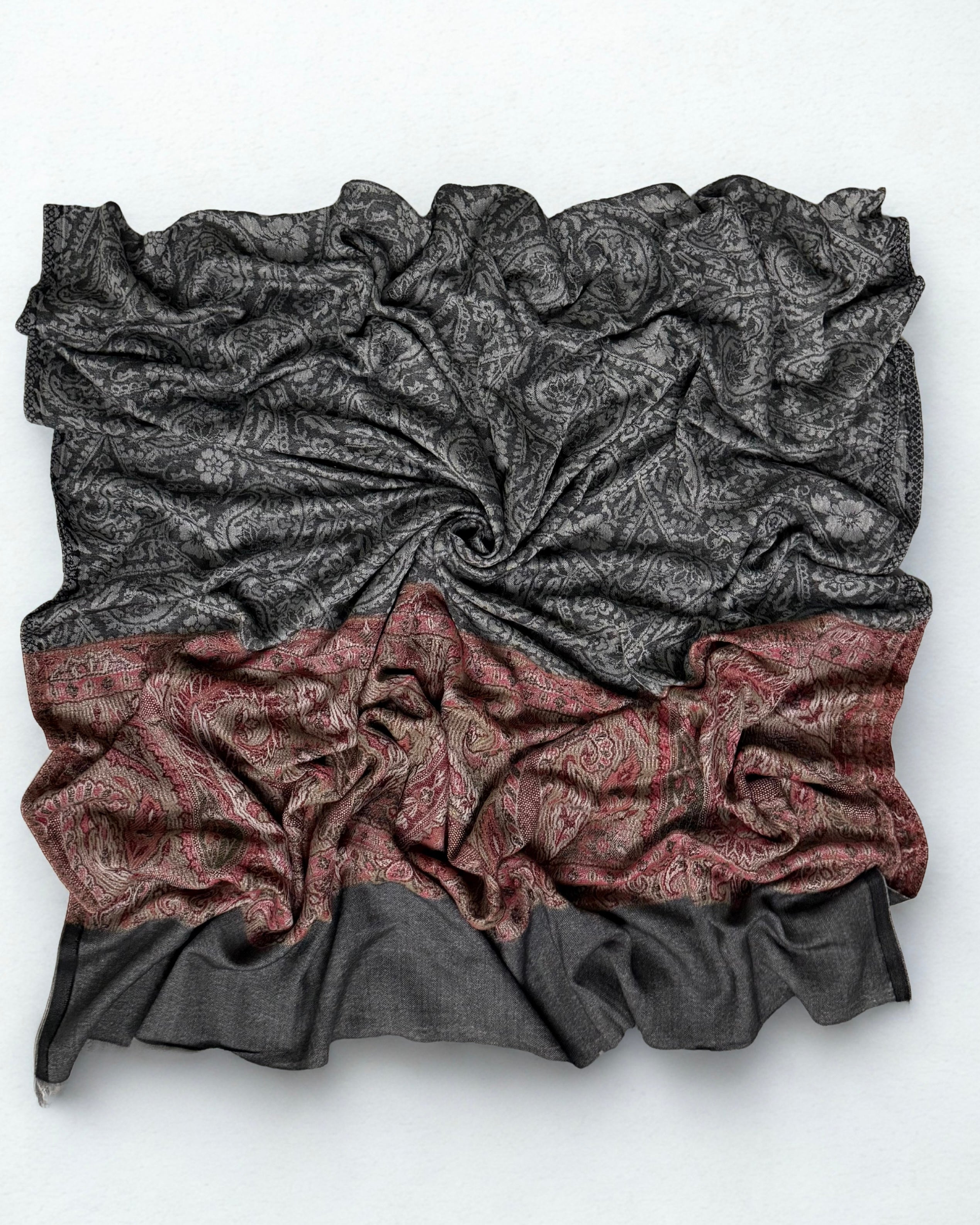 Full shawl laid flat, the paisley field reading as plain charcoal from a distance