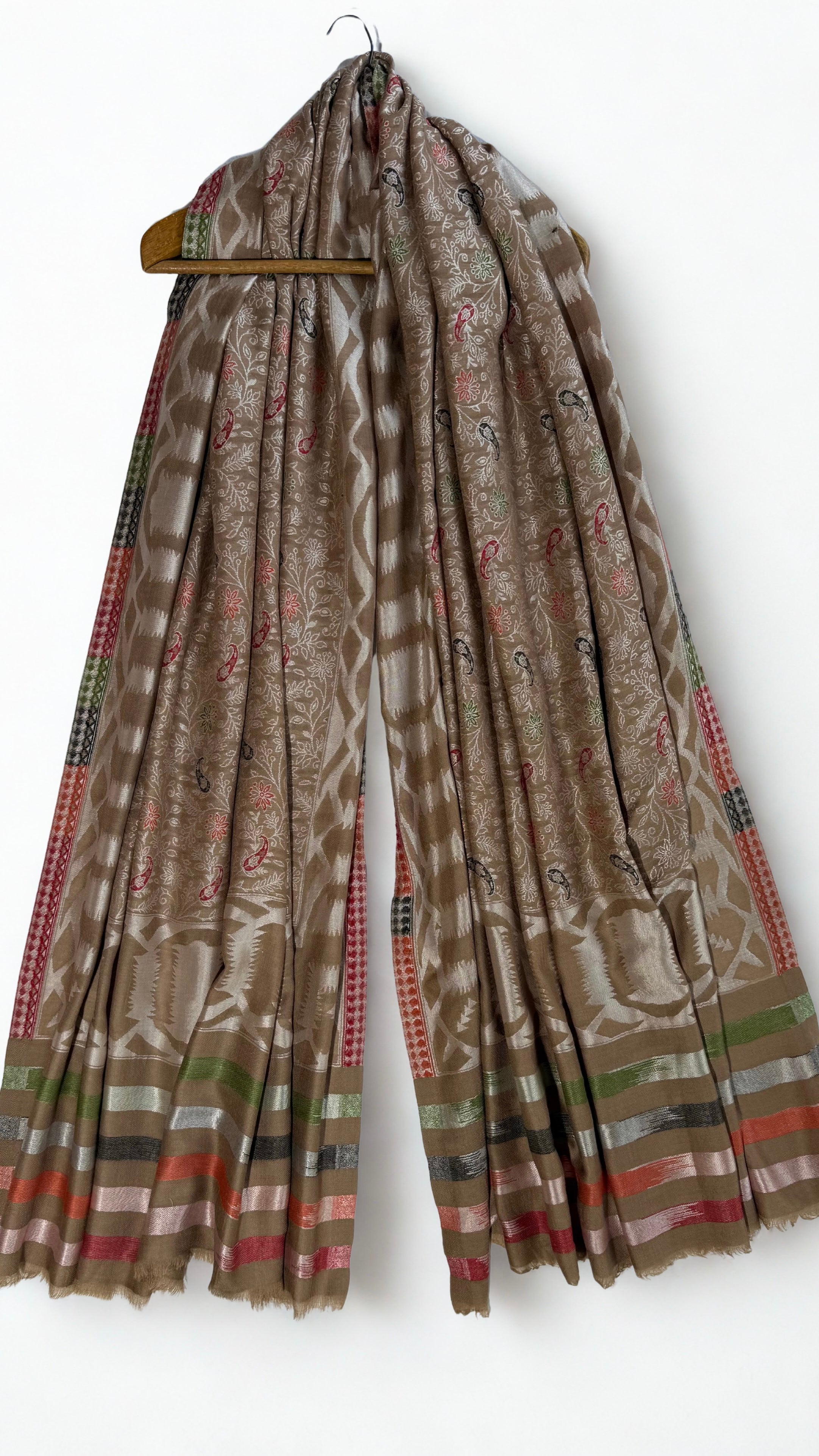 Detail of the small red, black and green paisley butis scattered across the silver flowering vine