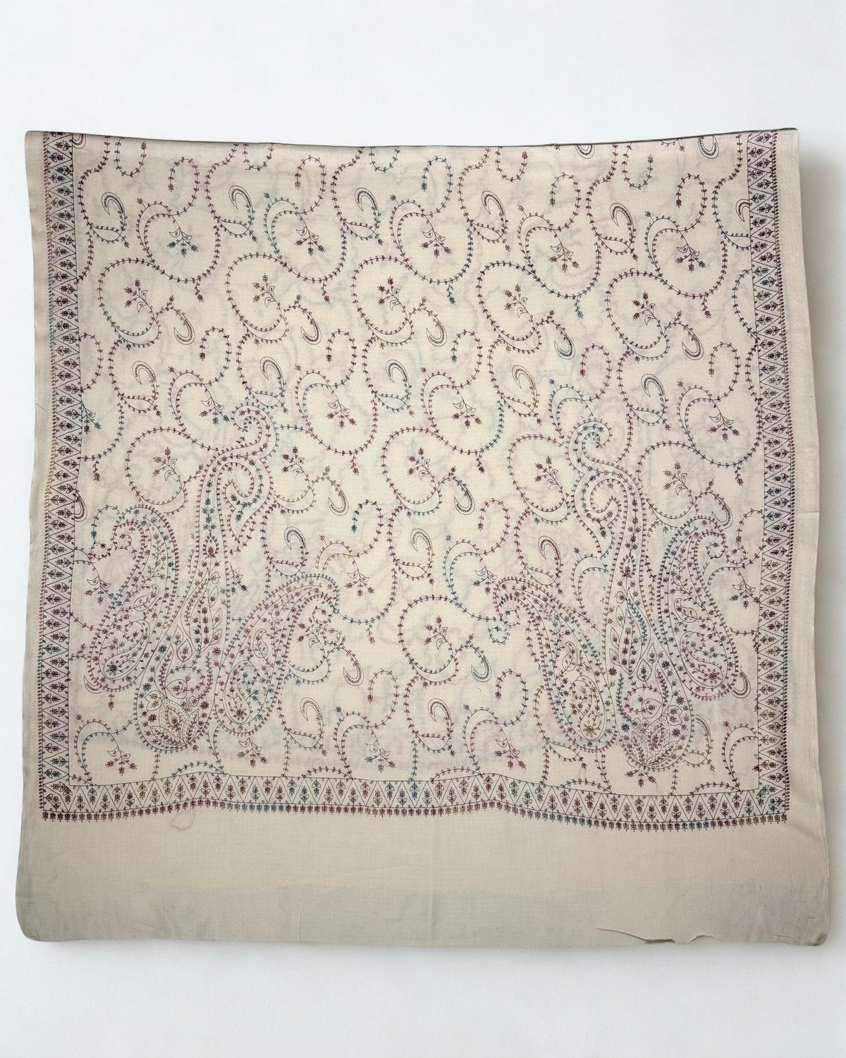 Full hand embroidery across the white Swati Shahtoosh shawl, with a border of triangular flower heads
