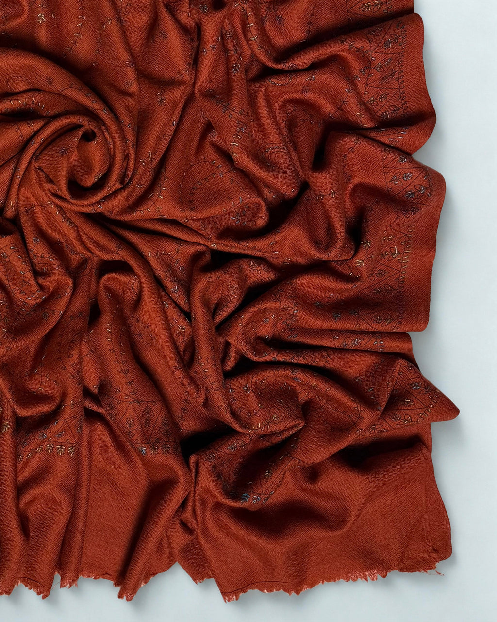 Close-up of the hand embroidery and triangular flower-head border on the rust Swati Shahtoosh shawl