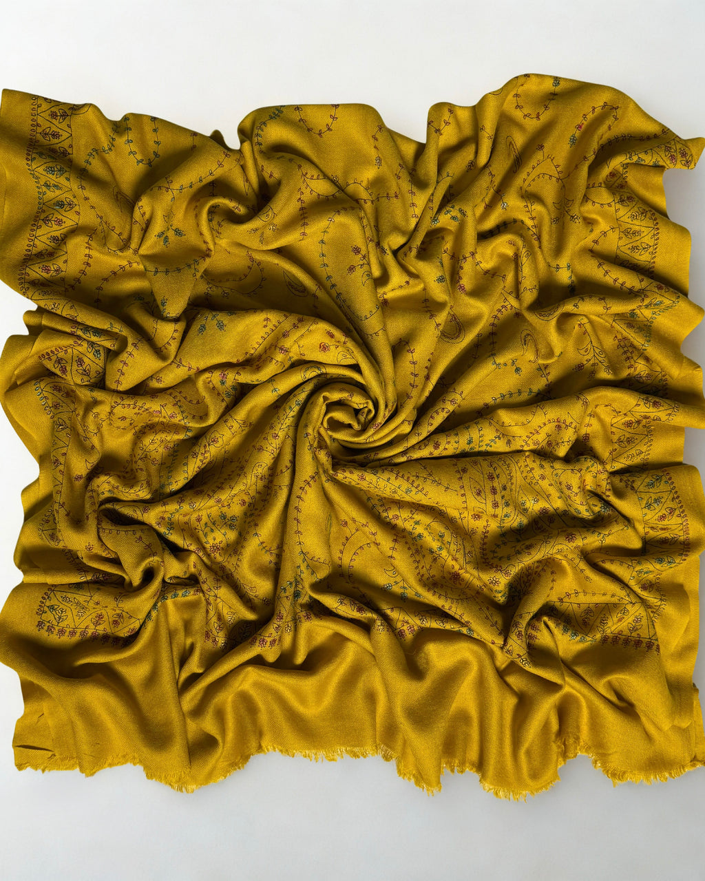 Mustard Swati Shahtoosh shawl swirled to show the soft handle of the wool and the tonal embroidery