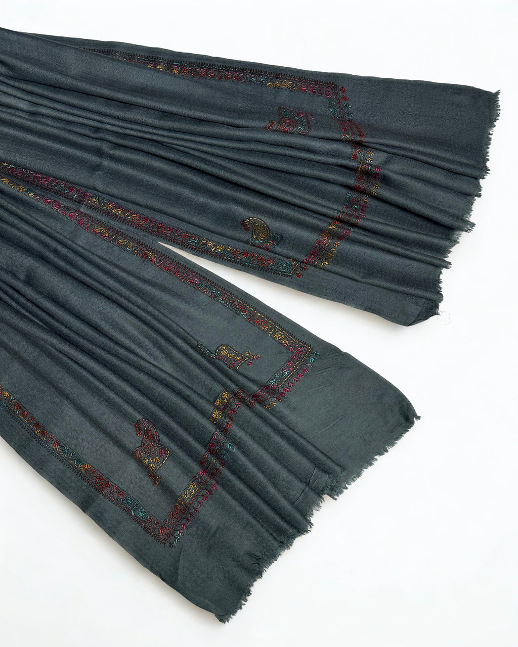 Slate grey Swati Shahtoosh shawl draped over a wooden hanger, embroidered border through the folds