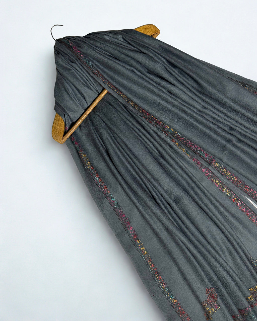 Ends of the slate grey Swati Shahtoosh shawl showing the embroidered border and corner paisleys