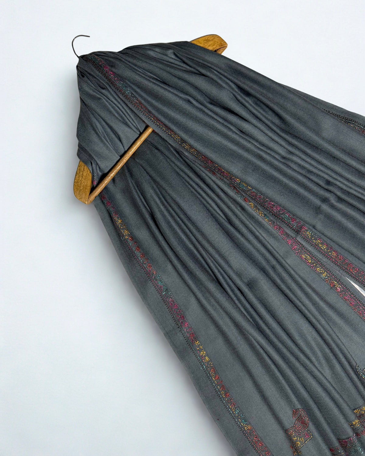 Ends of the slate grey Swati Shahtoosh shawl showing the embroidered border and corner paisleys