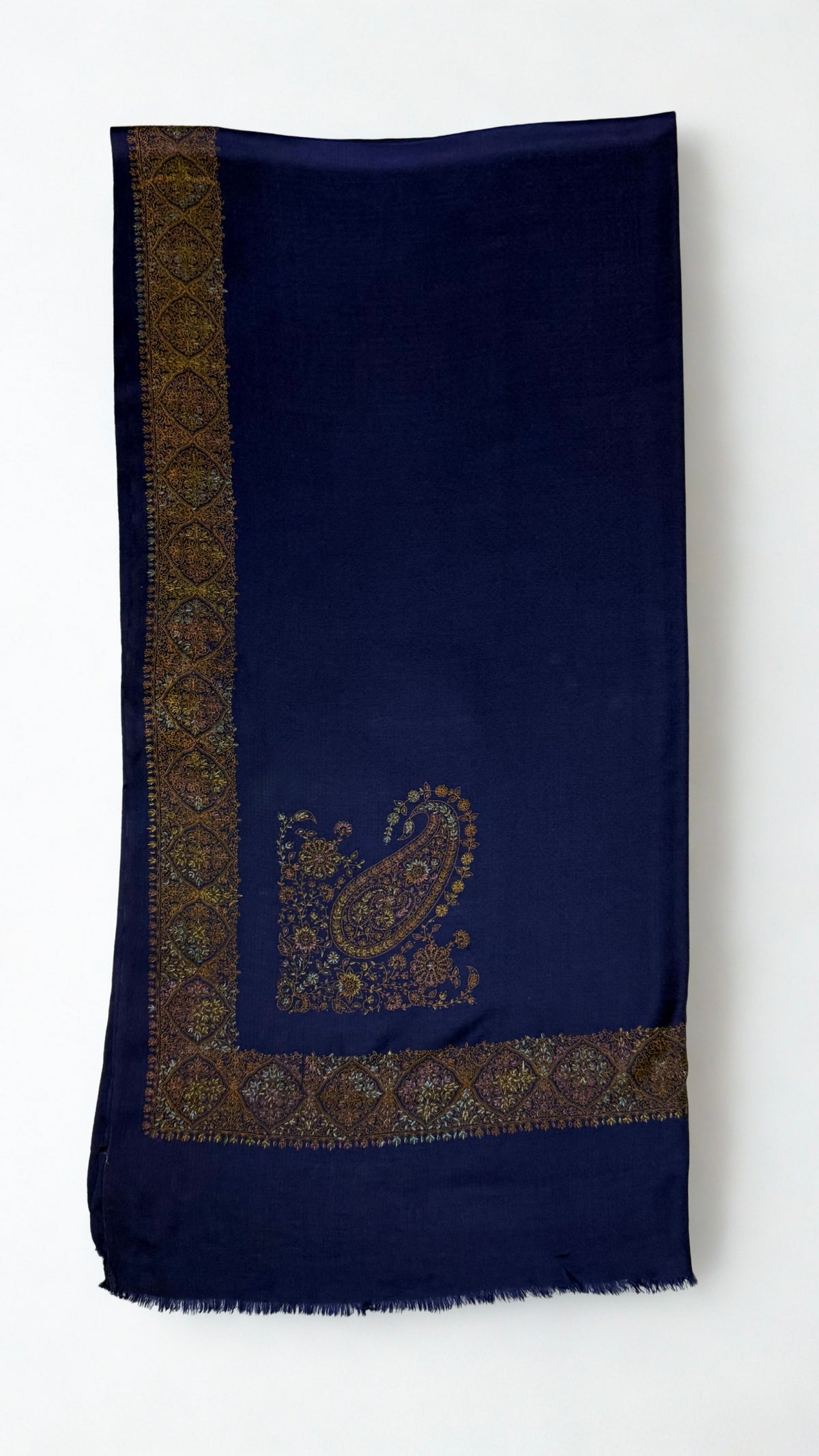 Navy Swati Shahtoosh shawl folded flat, the wide gold medallion border running down one edge with a large hand-embroidered paisley on the field