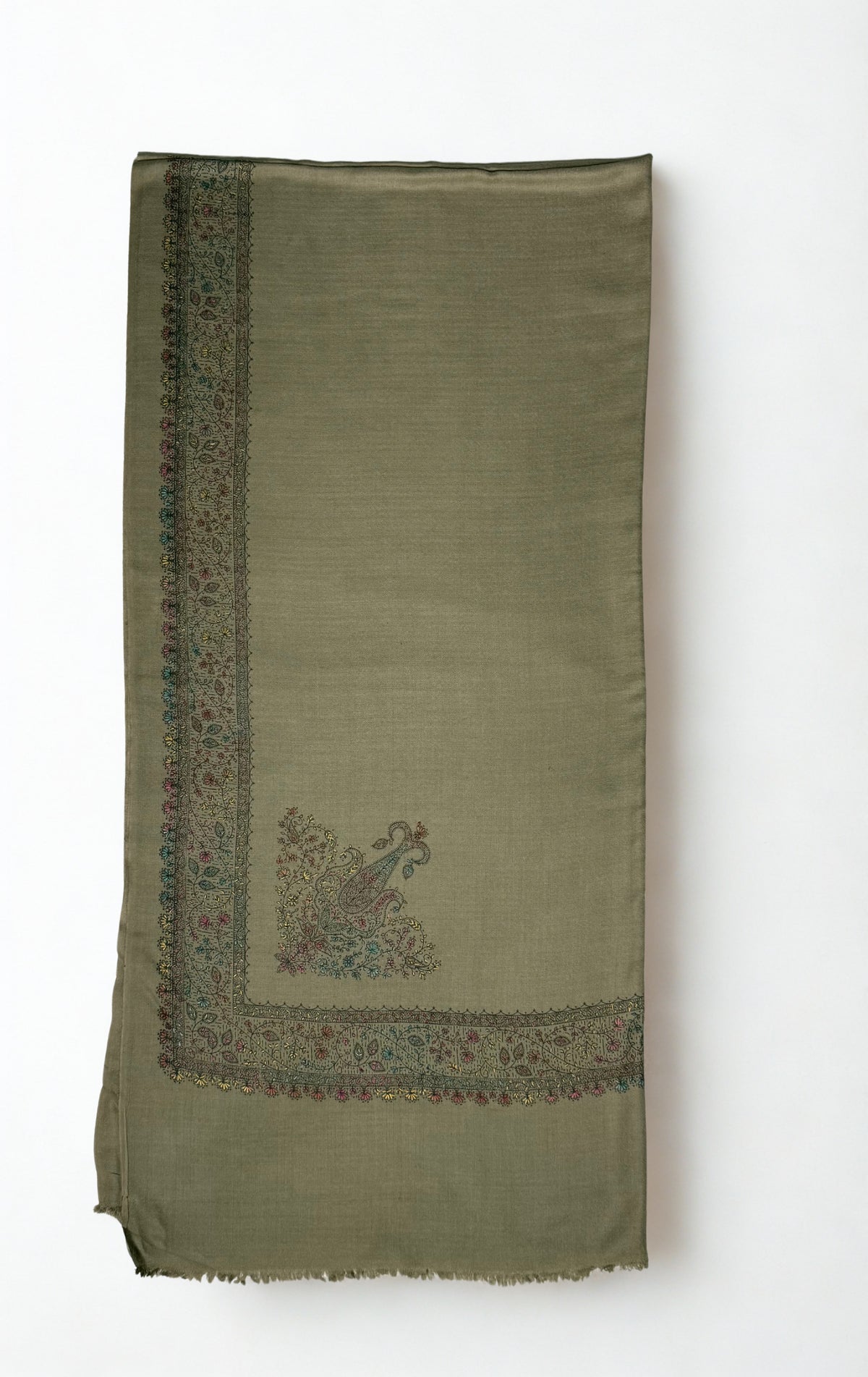Grey Swati Shahtoosh shawl with one corner turned back, showing the embroidered vine border mitred at the corner around two flowering paisley motifs