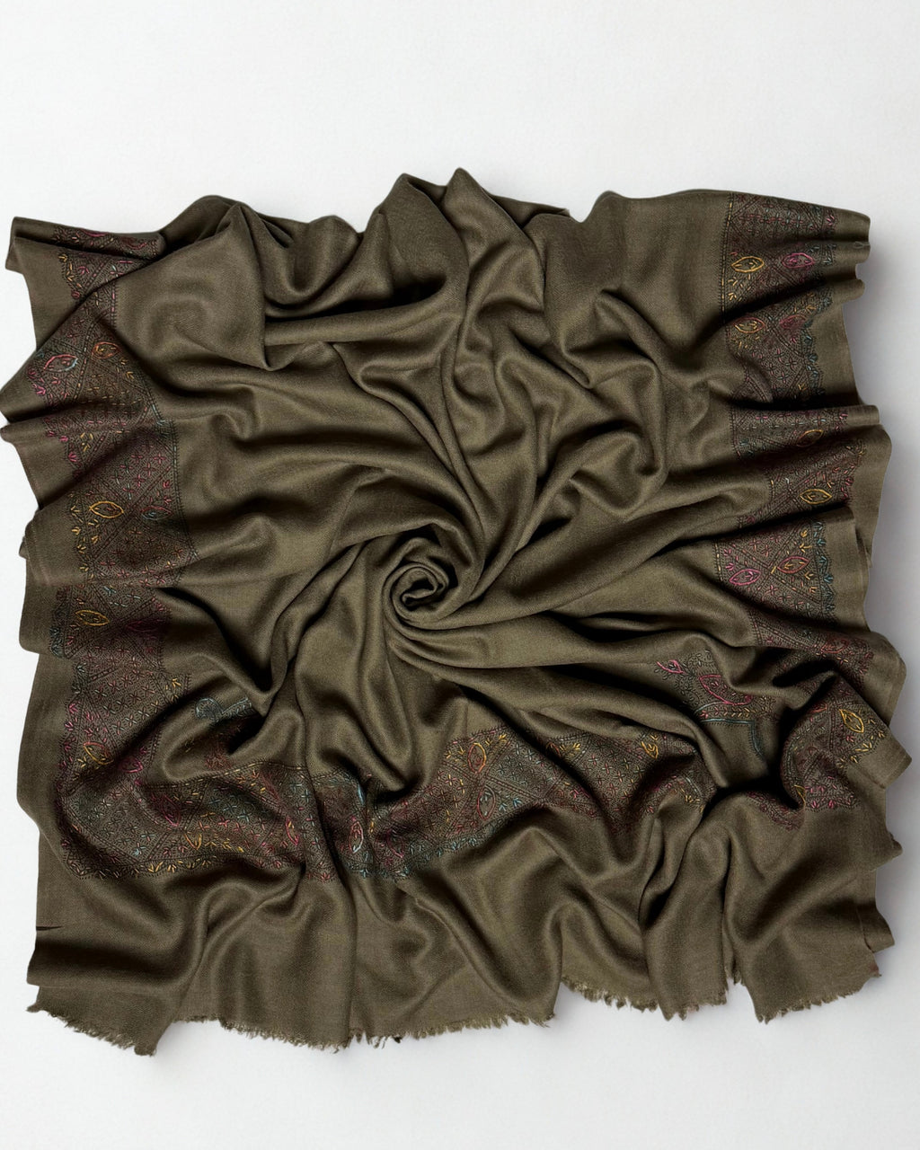 Olive brown Swati Shahtoosh shawl gathered in a swirl, the hand-embroidered lattice border framing the plain field