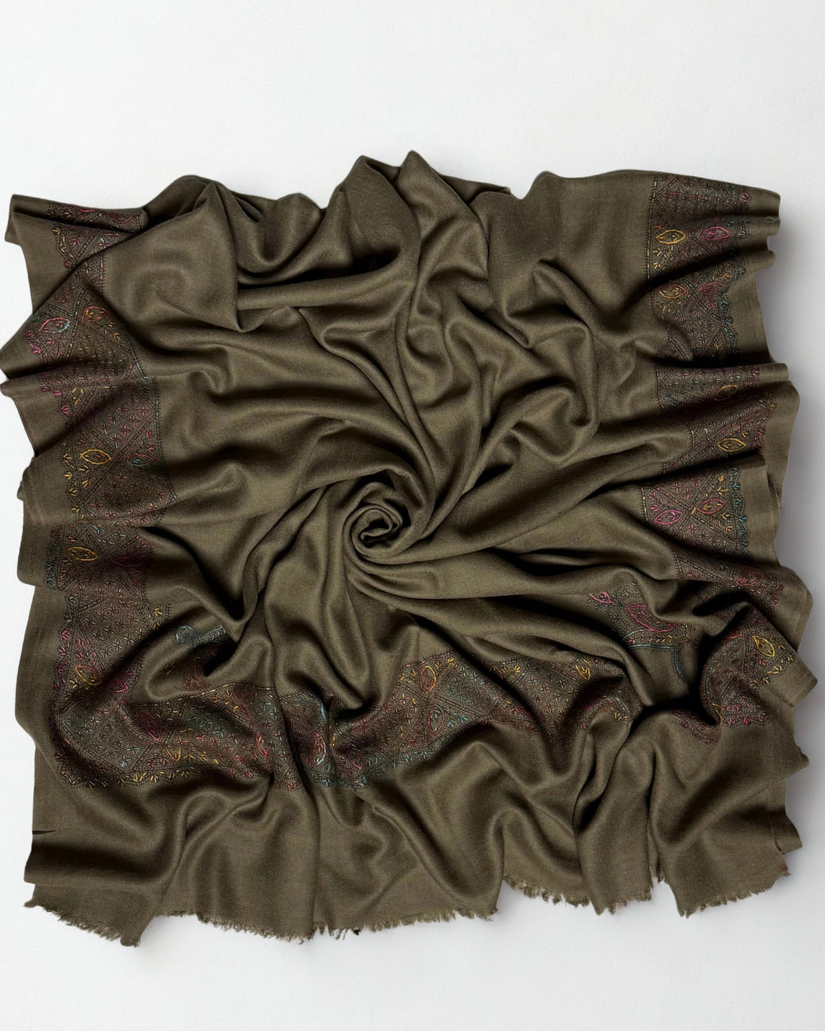 Olive brown Swati Shahtoosh shawl gathered in a swirl, the hand-embroidered lattice border framing the plain field
