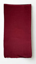 Maroon Swati Shahtoosh shawl folded lengthwise, showing the plain field, self-coloured diamond weave and fringed end