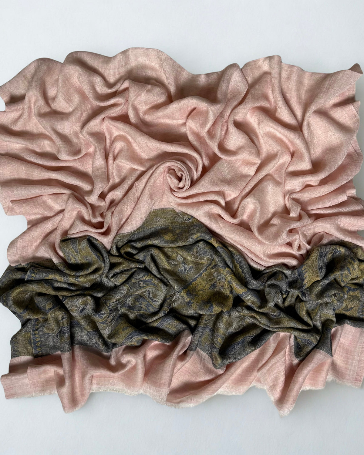 Blush pink Palladar ring shawl gathered in a swirl, the pale pink field above the dark woven paisley palla