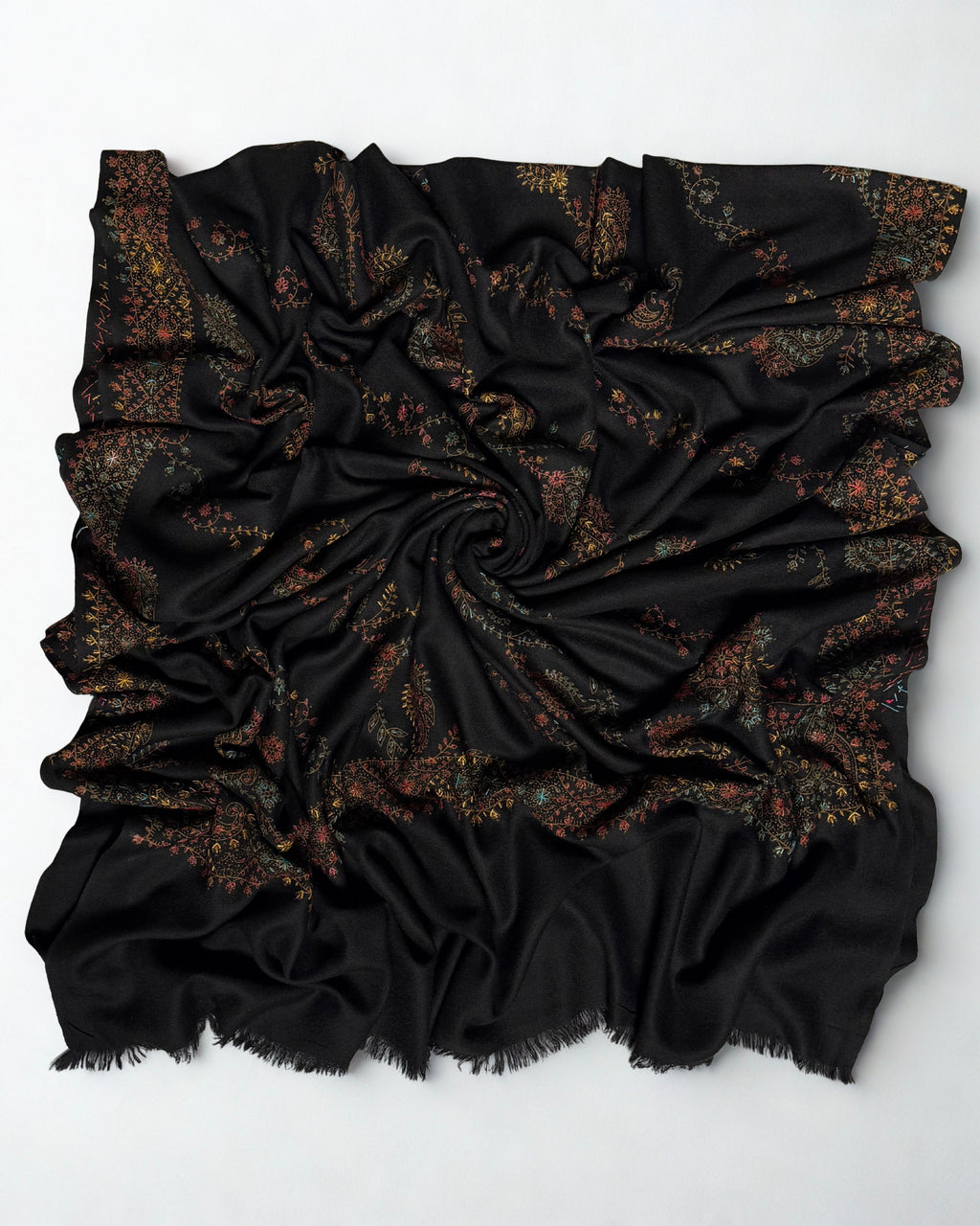 Black hand-embroidered Swati Shahtoosh shawl draped in a swirl, showing the embroidered border and fringed edges
