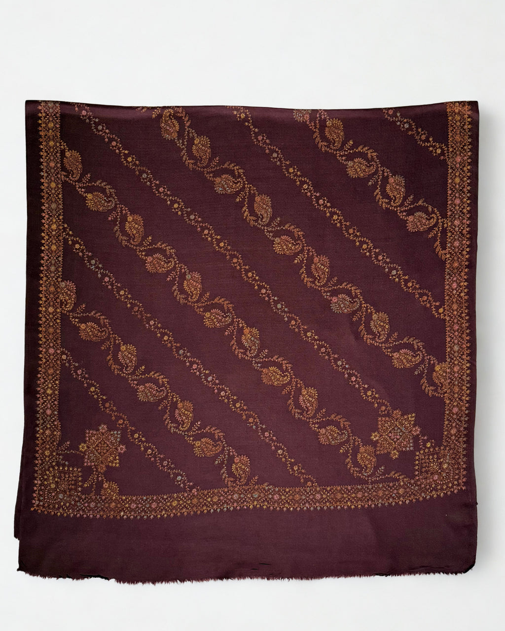Deep maroon Swati Shahtoosh shawl laid flat, full diagonal paisley jaal in copper, gold and rose with two embroidered corner medallions and border