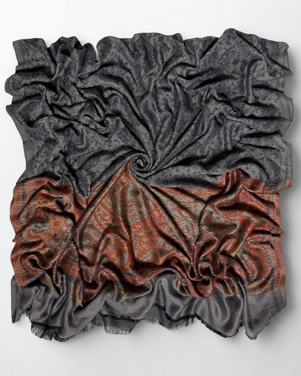 Charcoal fine pashmina ring shawl swirled from above, the dark paisley field over the rust paisley pallu