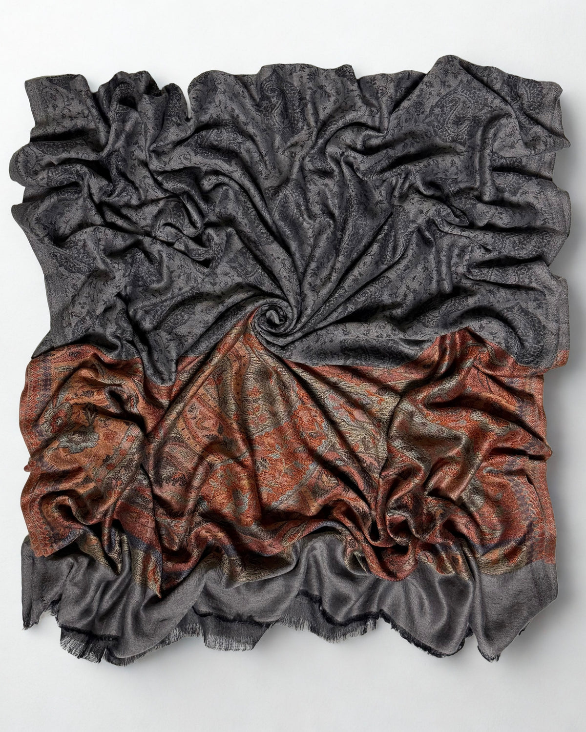 Charcoal fine pashmina ring shawl swirled from above, the dark paisley field over the rust paisley pallu