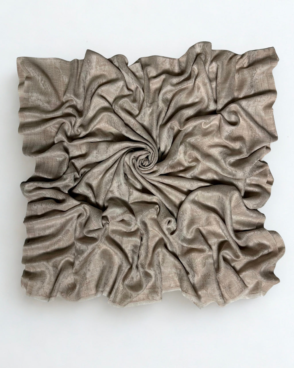 Stone taupe pashmina ring shawl swirled from above, showing its soft drape and subtle woven pattern
