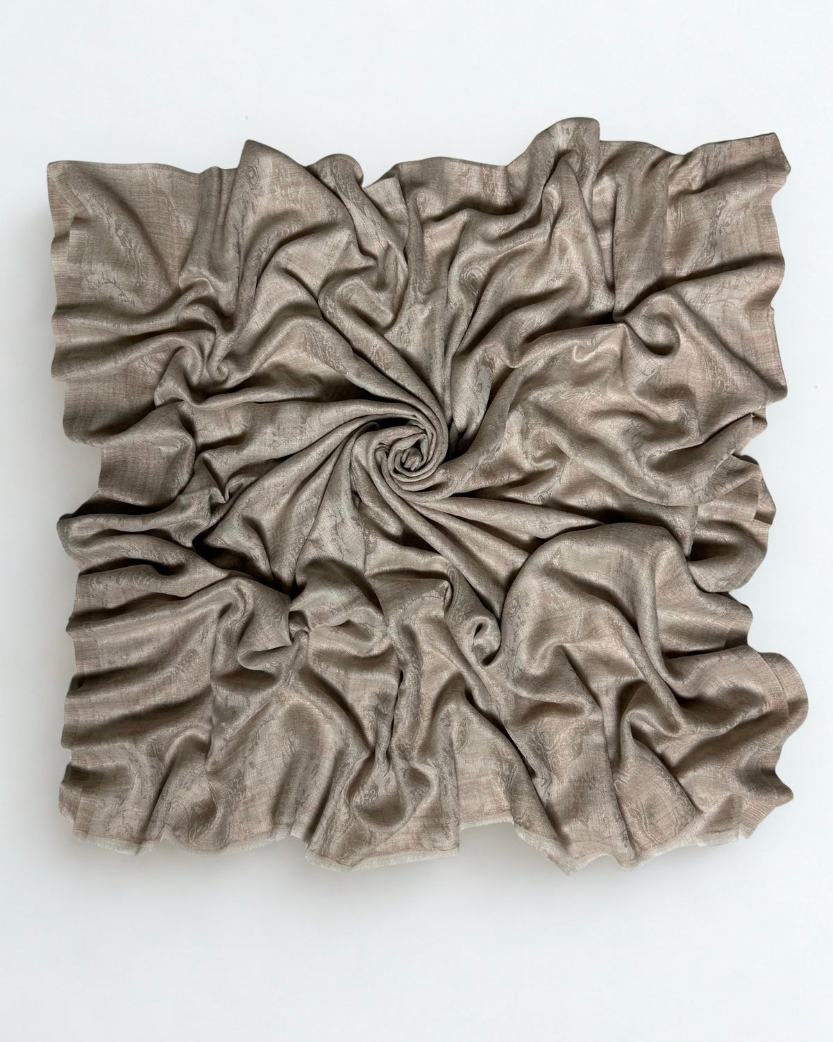 Stone taupe pashmina ring shawl swirled from above, showing its soft drape and subtle woven pattern