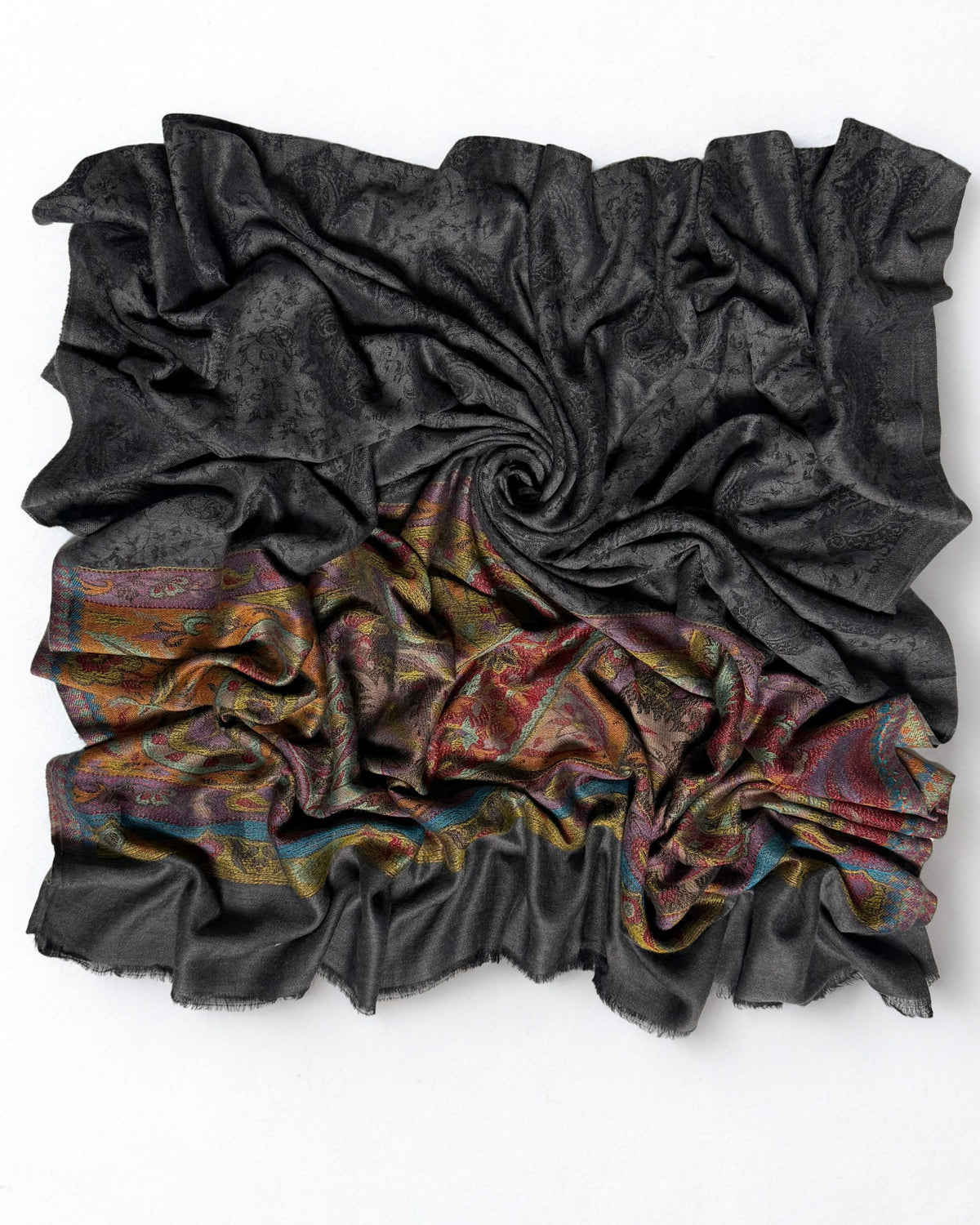 Dark charcoal fine pashmina ring shawl swirled, showing the black paisley field and warm woven palla
