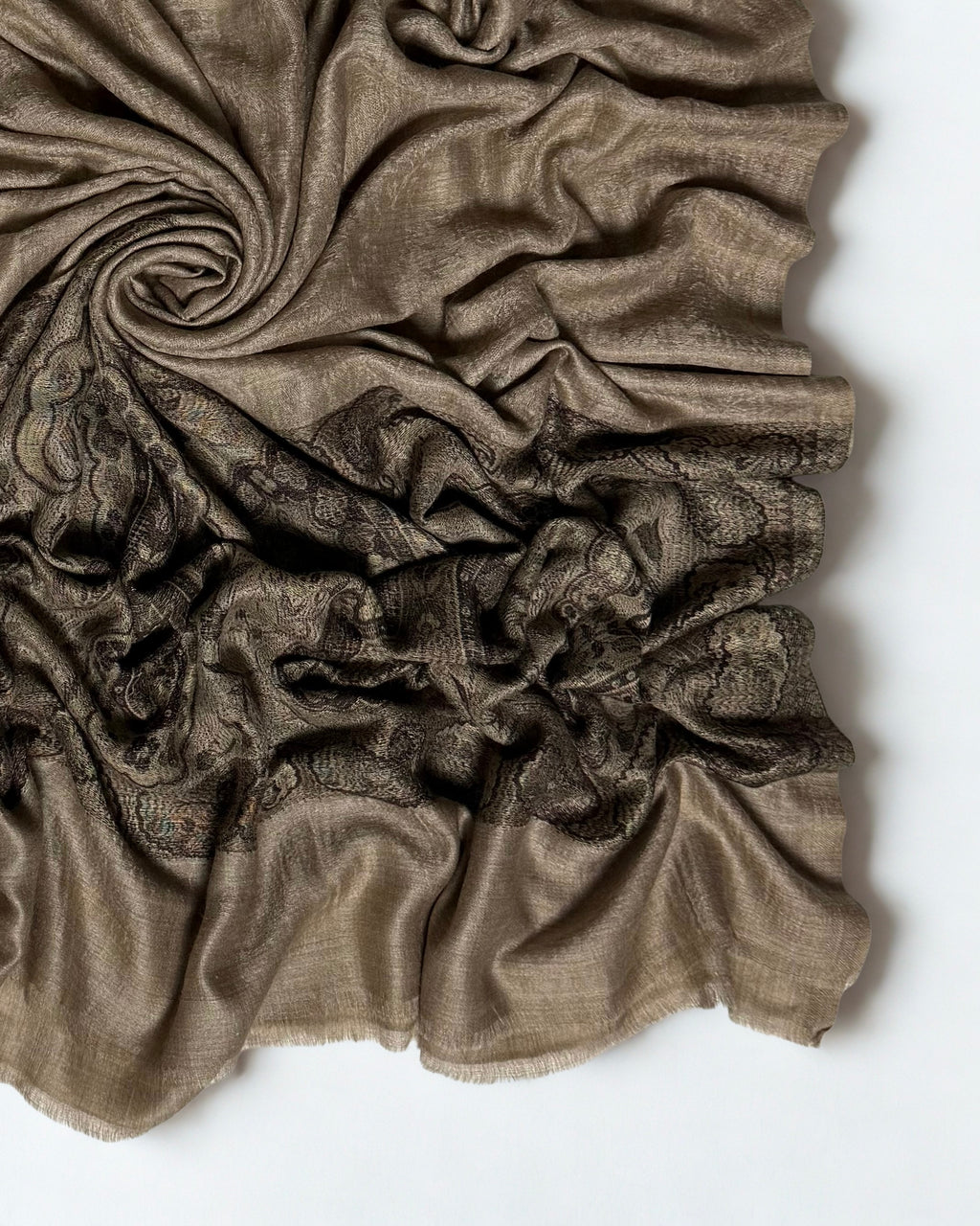 Close-up of a fawn Palladar shawl swirled to show the black paisley palla and plain fringed end