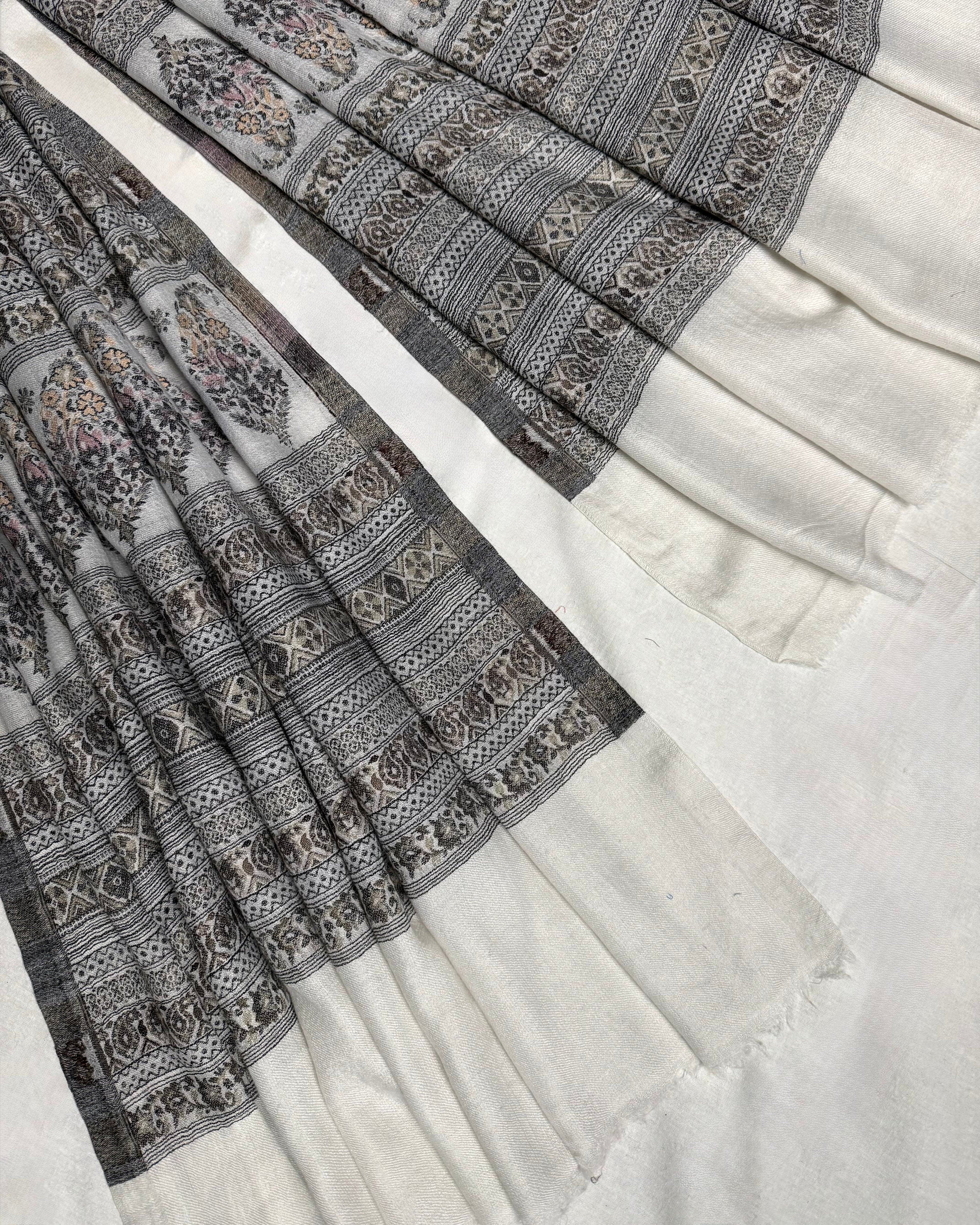 Detail of the paisley buta rows and fine geometric stripes woven in grey and stone on ivory pashmina