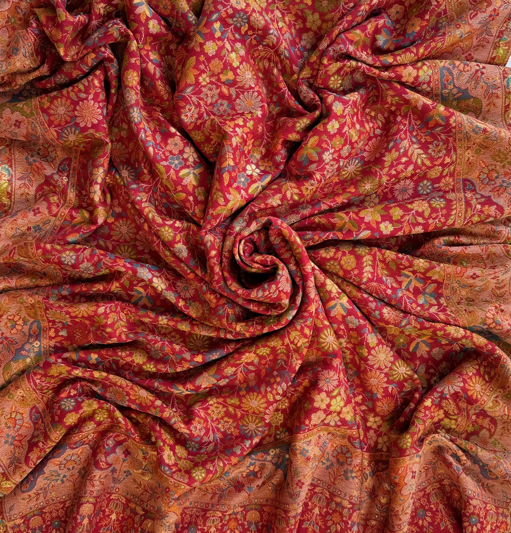 Crimson Zari Kani pashmina shawl arranged in folds, showing the border on all four sides and the fringed edge