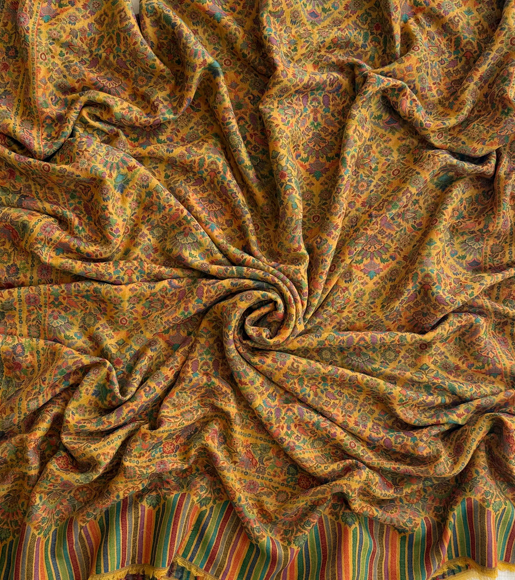 Close view of the teal, rose and violet flowering medallions woven into a marigold pashmina ground