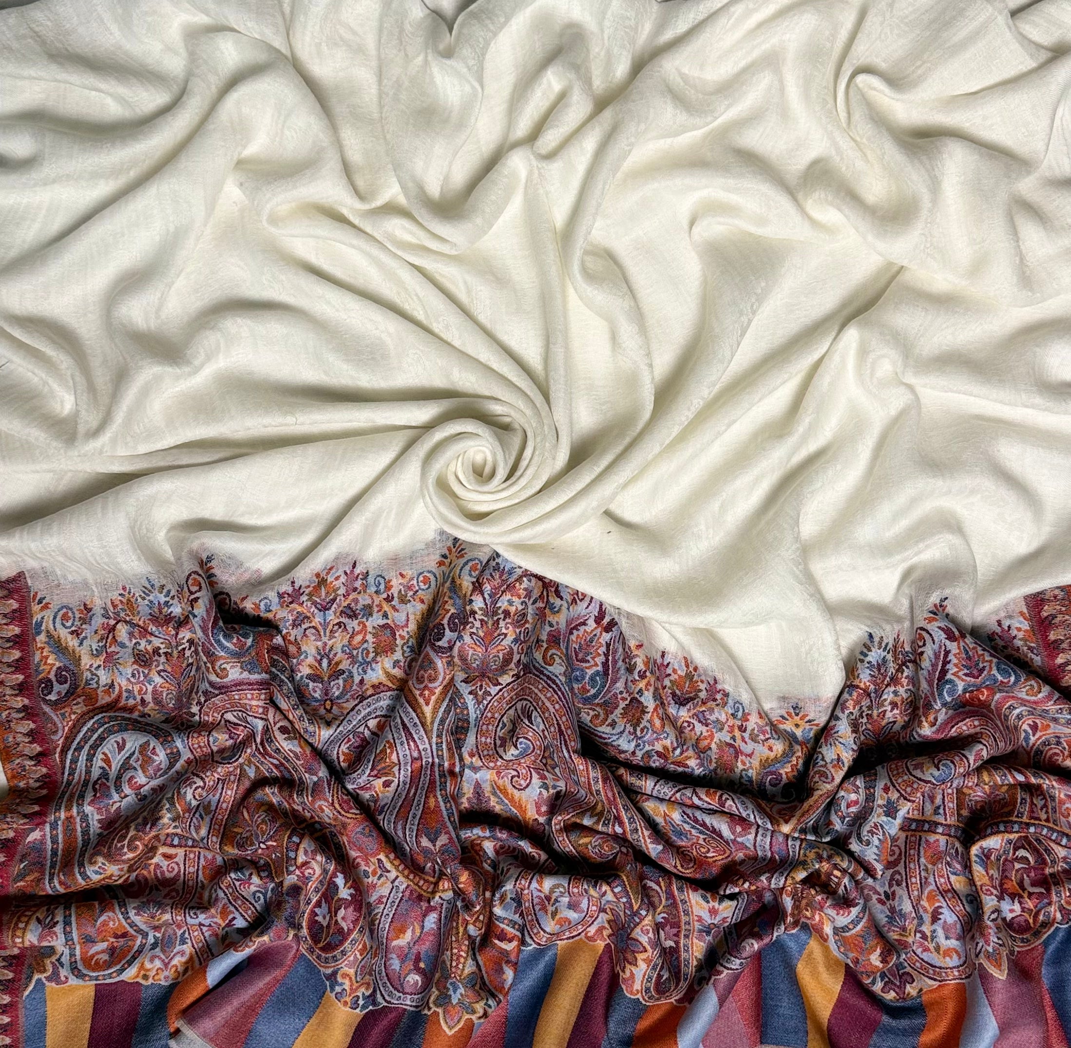 White ek rukh pashmina shawl drawn through a finger ring, showing the fineness of the hand-spun cloth