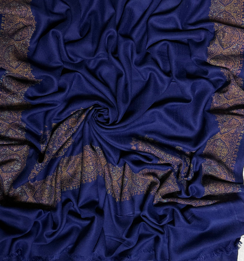 Close view of the navy Swati Shahtoosh shawl, showing the hand-embroidered gold medallion border and the self-coloured diamond lattice in the weave