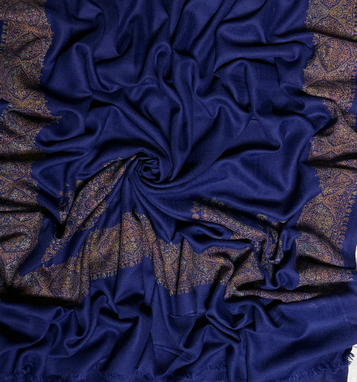 Close view of the navy Swati Shahtoosh shawl, showing the hand-embroidered gold medallion border and the self-coloured diamond lattice in the weave