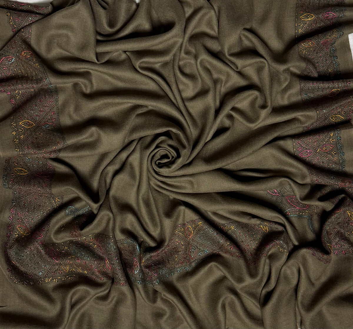 Close view of the olive brown Swati Shahtoosh shawl, showing the hand-embroidered jali lattice border in rose, teal and gold against the self-coloured diamond weave