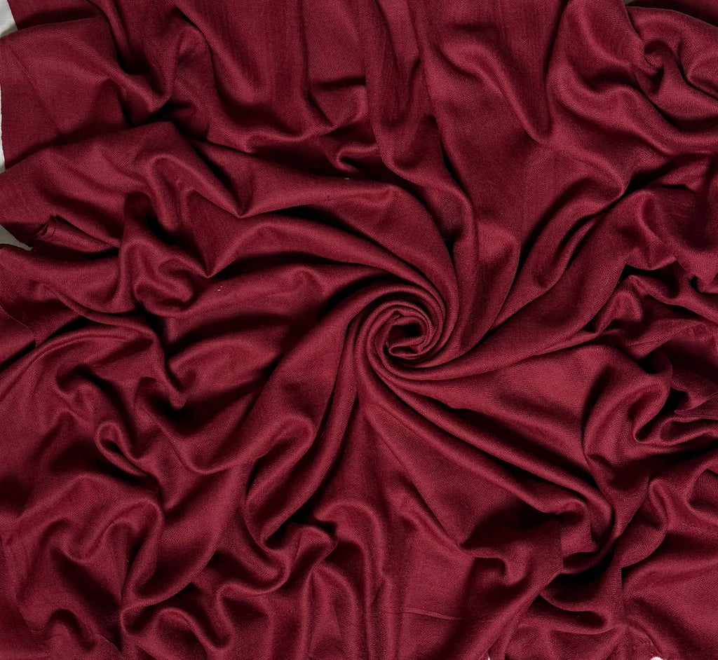 Close view of the maroon Swati Shahtoosh shawl, showing the self-coloured diamond weave and fringed end