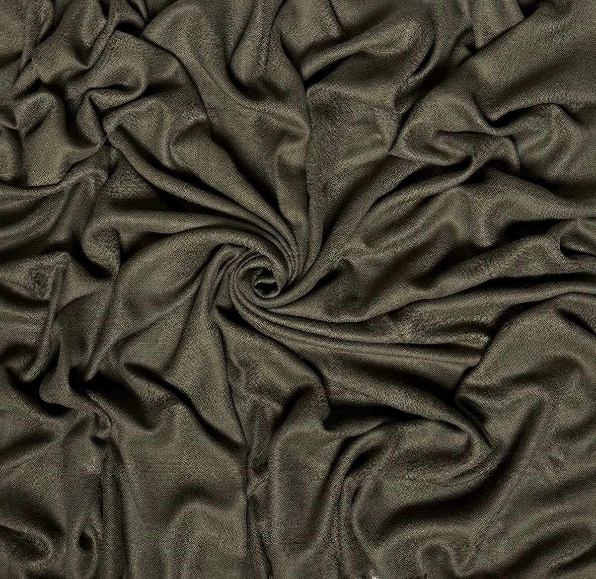 Close view of the olive Swati Shahtoosh shawl, showing the self-coloured diamond weave and fringed end
