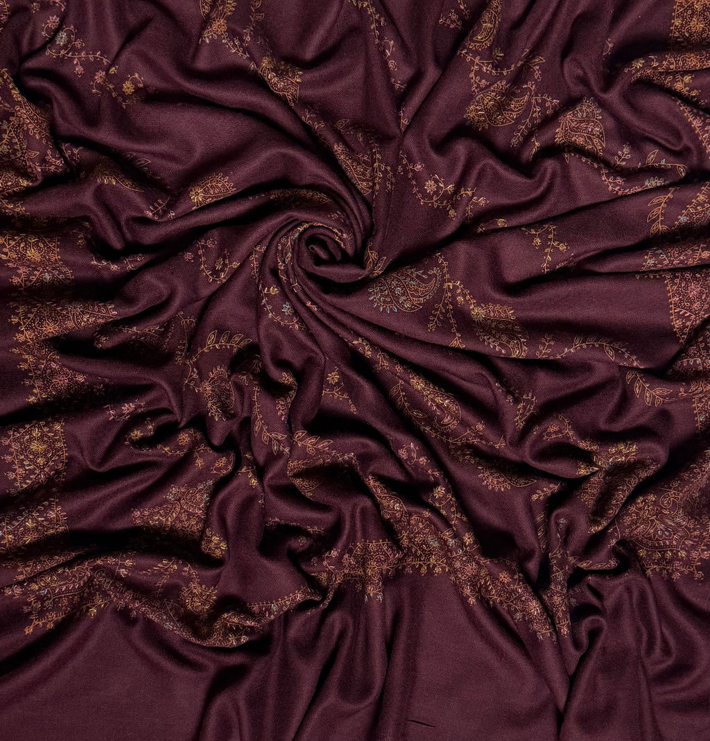 Deep maroon Swati Shahtoosh shawl draped in a swirl, showing the full spread of hand embroidery across the cloth