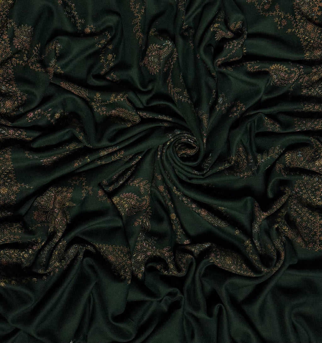 Forest green Swati Shahtoosh shawl draped in a swirl, showing the full spread of hand embroidery across the cloth