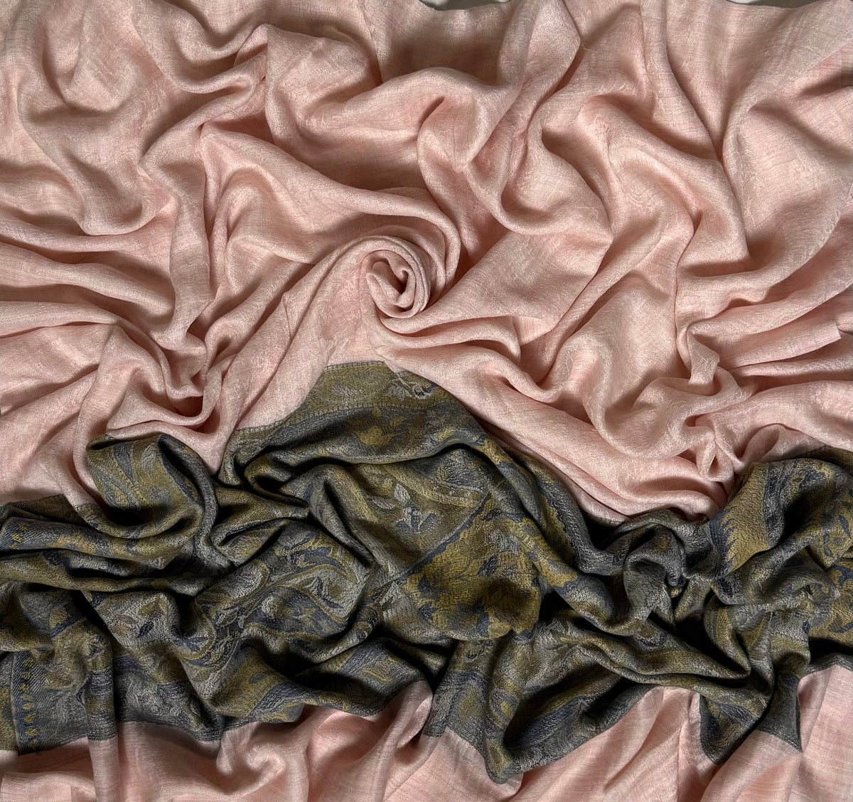 Close view of the blush pink Palladar ring shawl, showing the woven paisley palla in olive, moss and indigo against the pale pink field