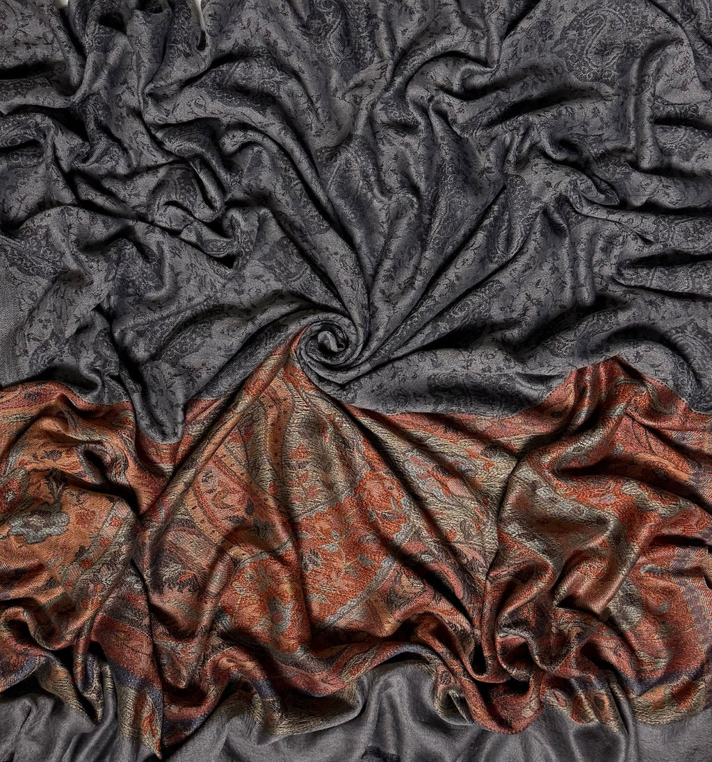 Charcoal Palladar shawl swirled to show the sheen of the fine pashmina and the woven rust paisley end