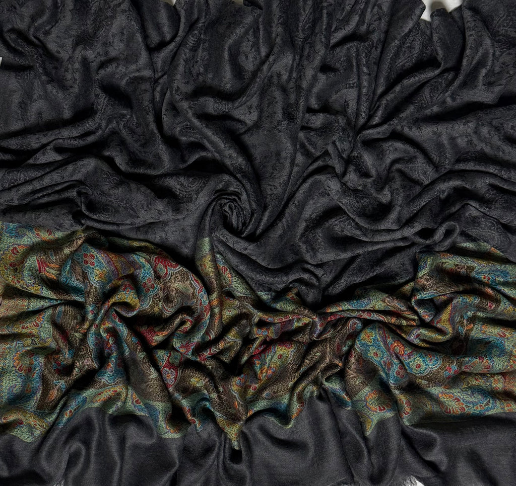 Dark charcoal Palladar shawl swirled to show the sheen of the fine pashmina and the woven jewel-tone paisley end