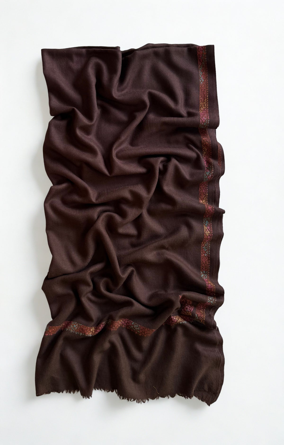 Close view of the rose, coral and teal hand embroidery against the deep espresso brown ground