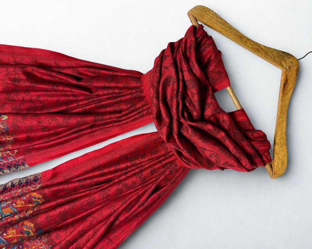 Close view of the self-woven floral vine on the deep red pashmina ground