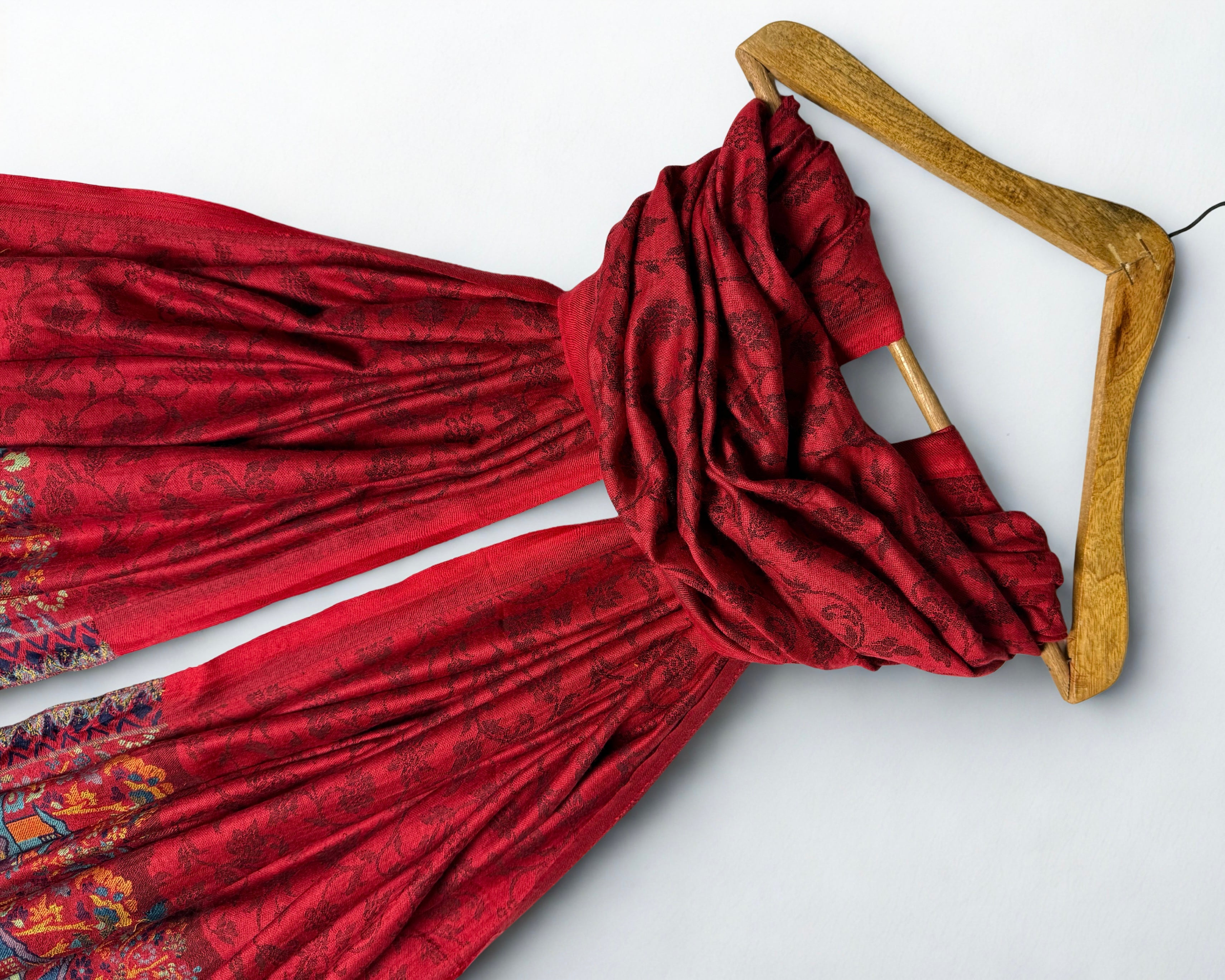 Close view of the self-woven floral vine on the deep red pashmina ground